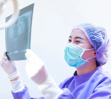 Dental professional examining X-ray image