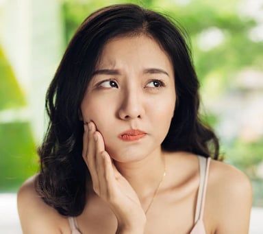 Young woman showing concern about dental pain