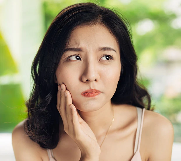 Young woman showing concern about dental pain