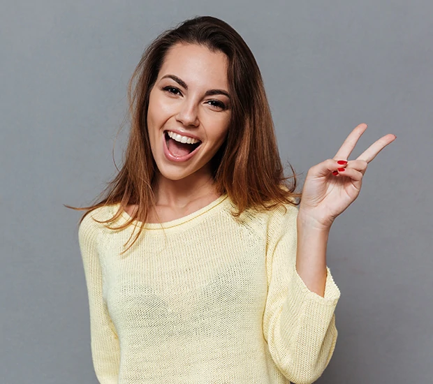 Happy woman making peace sign with hand