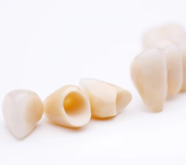 Dental crowns arranged on a white background.
