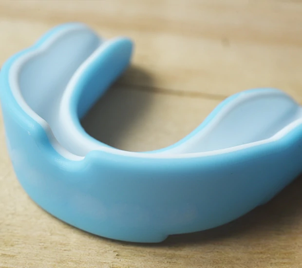 Blue dental mouthguard on wooden surface