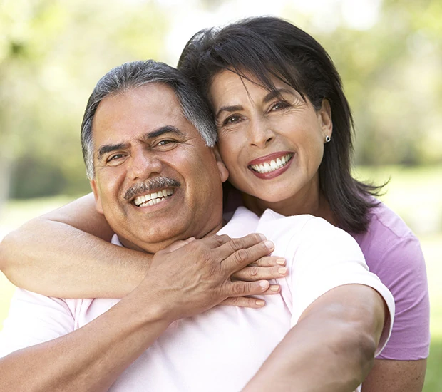 Couple smiling together in a park setting